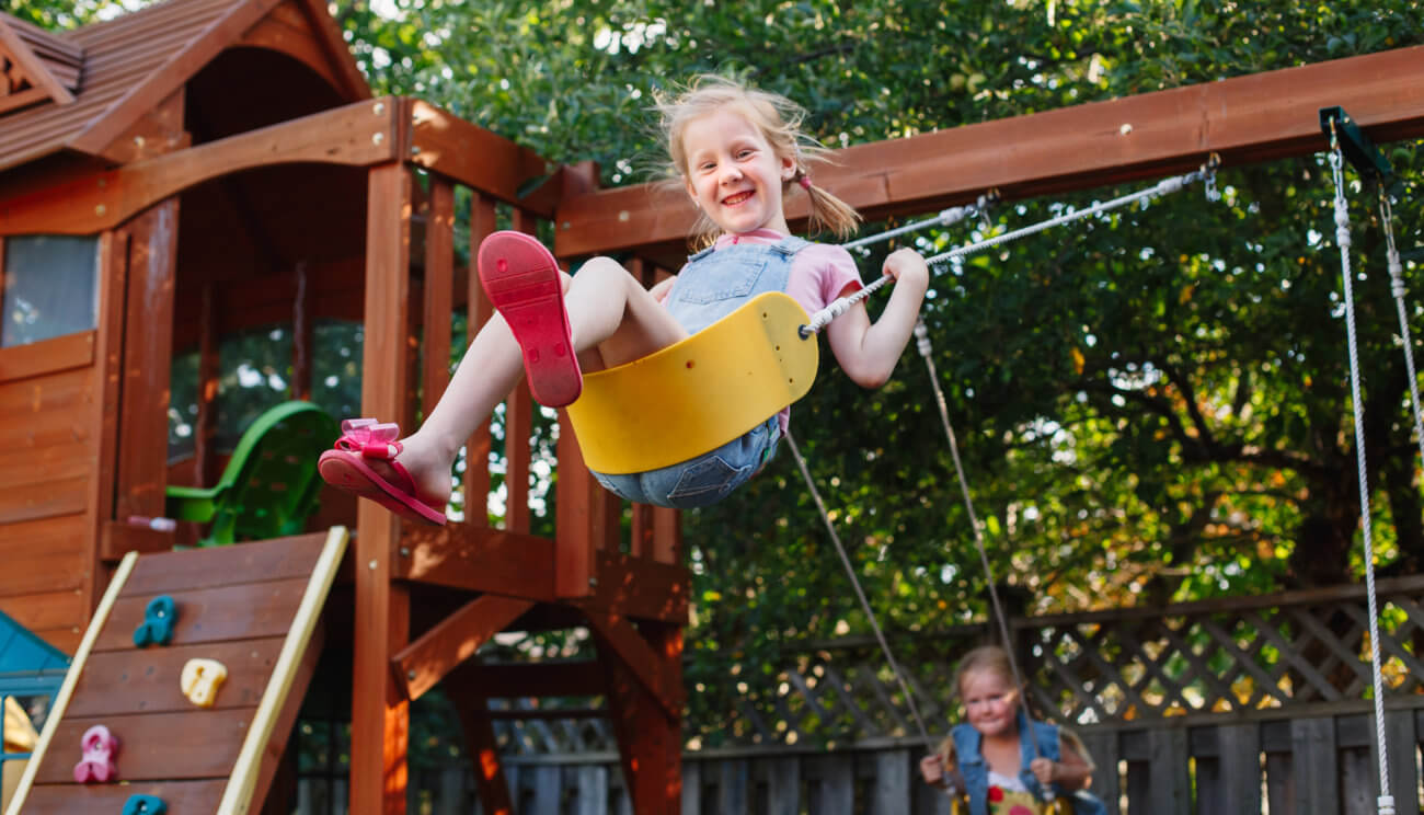 Child playing on swing playset