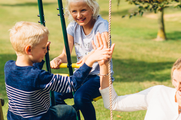 Kids playing on wooden swings