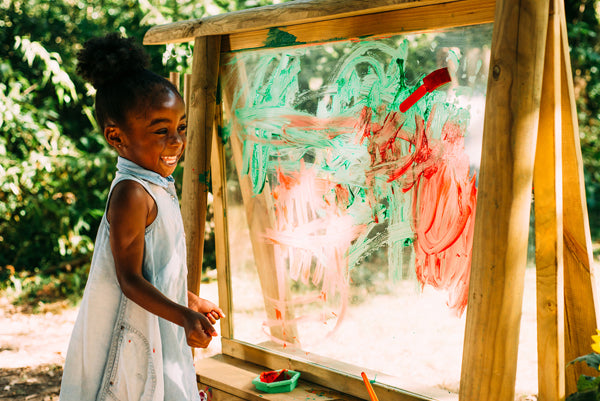 Little girl painting on Plum Play Create and Paint Easel