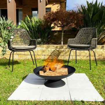 Black cast iron firepit for backyards and garden areas to provide outdoor heating and exterior design
